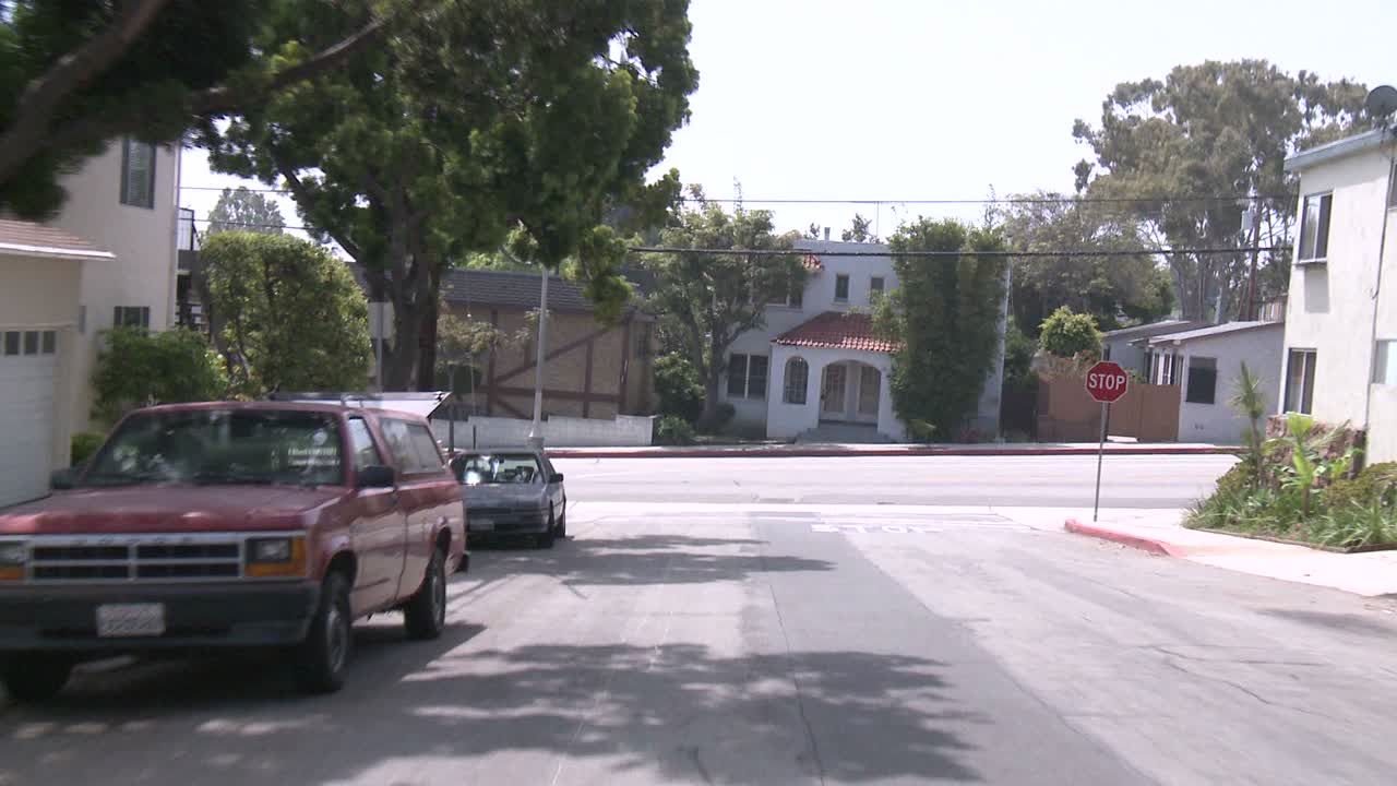 후면 유리 1을 통해 보이는 산타모니카 캘리포니아의 거리를 따라 자동차가 이동합니다.