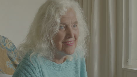 close up a smiling elderly woman sitting in a rocking chair