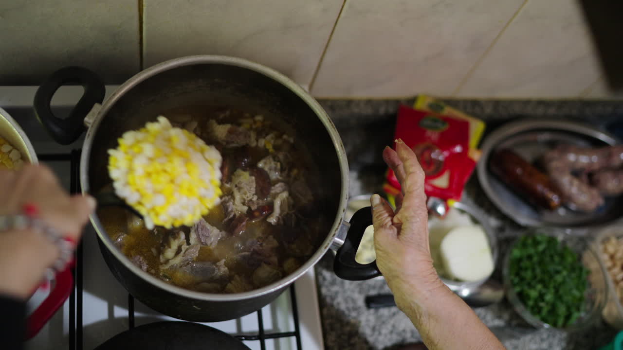 Woman's hand cooking locro in saucepan. Traditional Argentine food. Close up