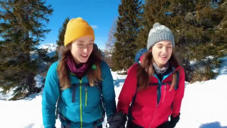 two happy women snowshoeing through a snowy forest landscape