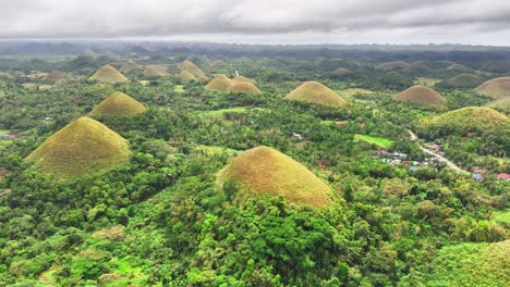 drone slowly pulls back revealing the unique geological formations of the chocolate hills in bohol, philippines, a surreal tropical landscape of grassy conical hills covered in green vegetation