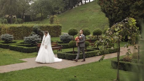 Schöne-Frischvermählte-Kaukasische-Braut-Und-Bräutigam-Mit-Blumenstrauß-Im-Park,-Erstes-Treffen-Des-Hochzeitspaares