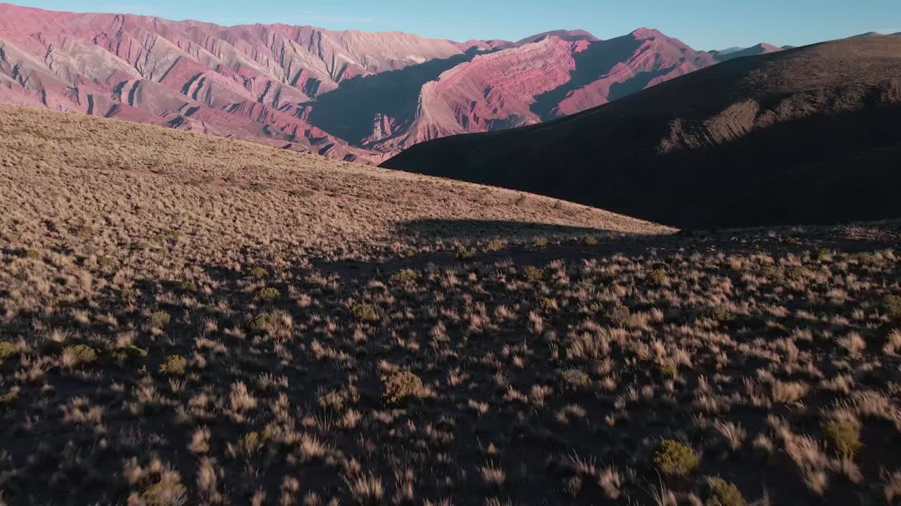 toma de adelantamiento de una mujer caminando sola en la naturaleza con impresionantes montañas de fondo, norte de argentina