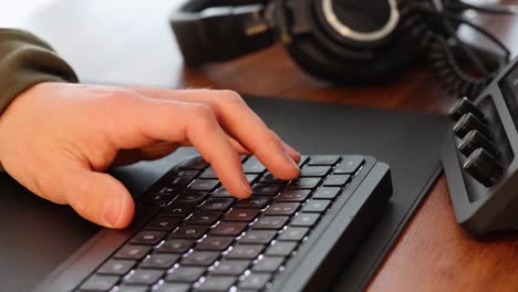 close-up of male hand operating a keyboard in a professional video editing setup