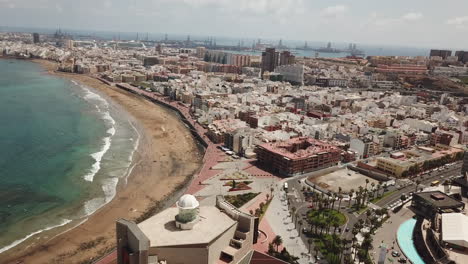 General-aerial-shot-over-Las-Canteras-beach-in-the-city-of-Las-Palmas,-flying-over-the-Alfredo-Kraus-auditorium