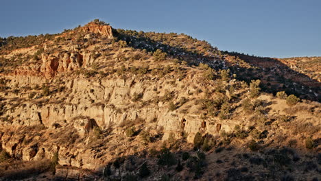 aerial shot of a dramatic natural arch in utah’s red rock country, glowing in the morning light.