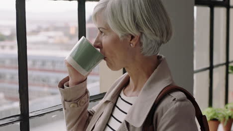 mature business woman drinking coffee at home enjoying relaxed morning looking out window planning ahead thinking successful caucasian entrepreneur contemplating retirement