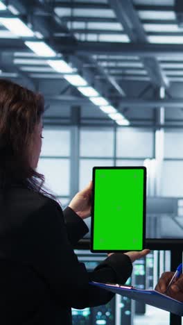 vertical video workers using mockup device in server room, checking infrastructure reliability
