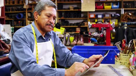 zapatero que usa una tableta digital