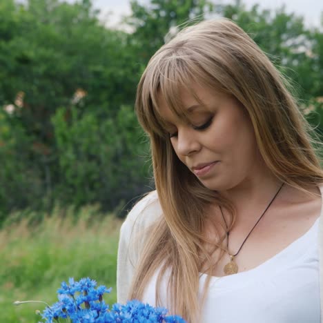 pregnant woman holding blue flowers