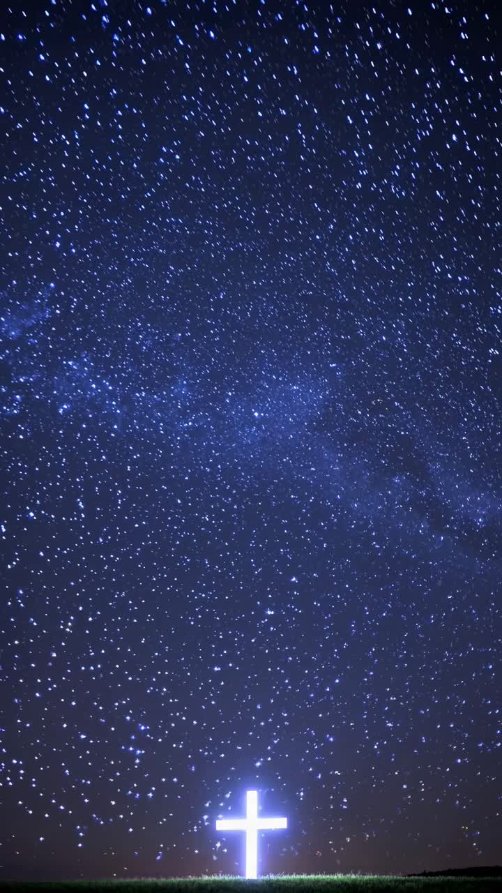 A glowing cross under a starry sky, captured from a low-angle
