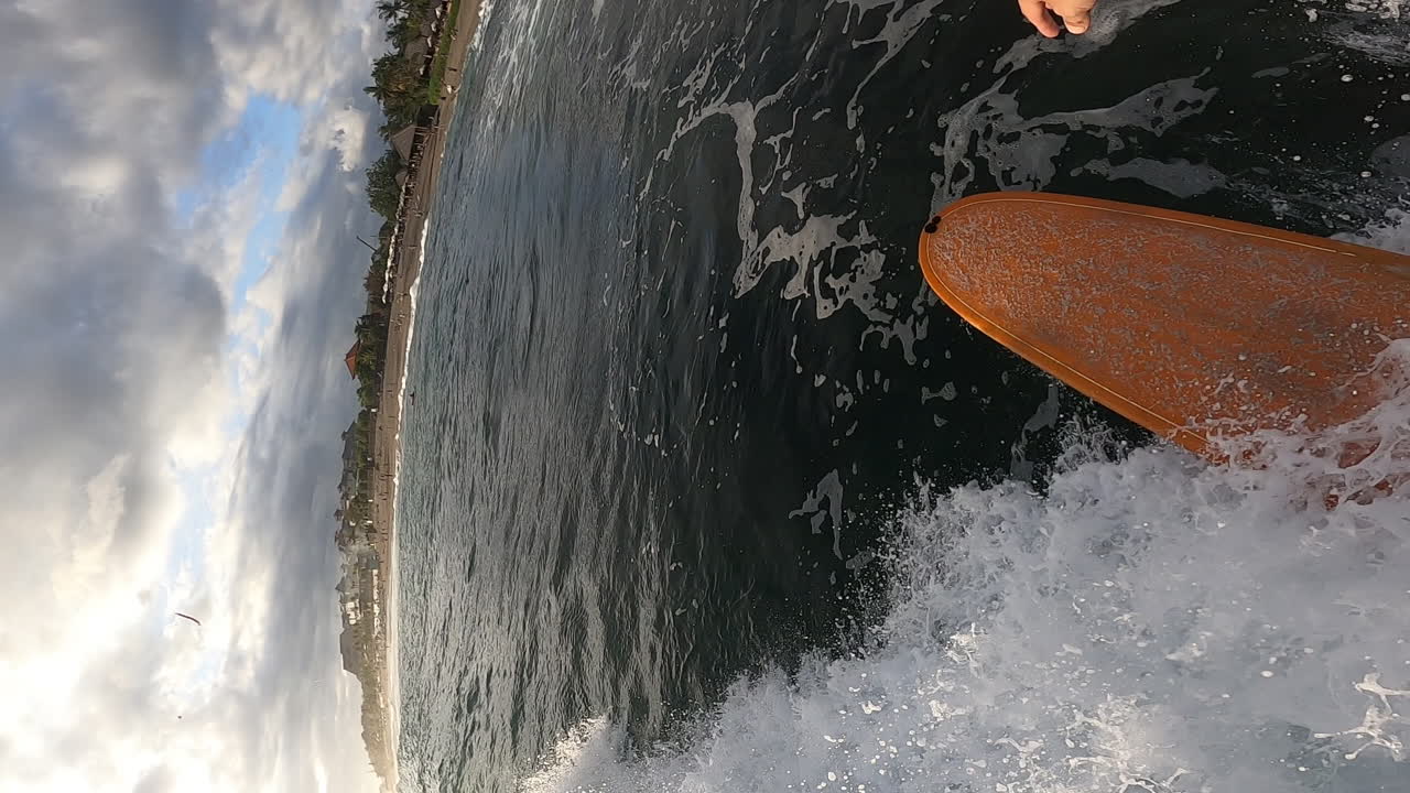 punto de vista de la persona que practica surf en las olas del océano tropical en una tabla de espuma amarilla