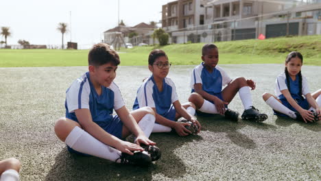 soccer, sports team and kids relax on field