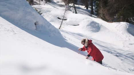 Caucasian-man-using-ice-axes-to-climb-snowy-slope-in-slow-motion-from-above