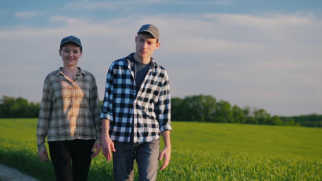 two farmers walk among the fields of green wheat talking 1