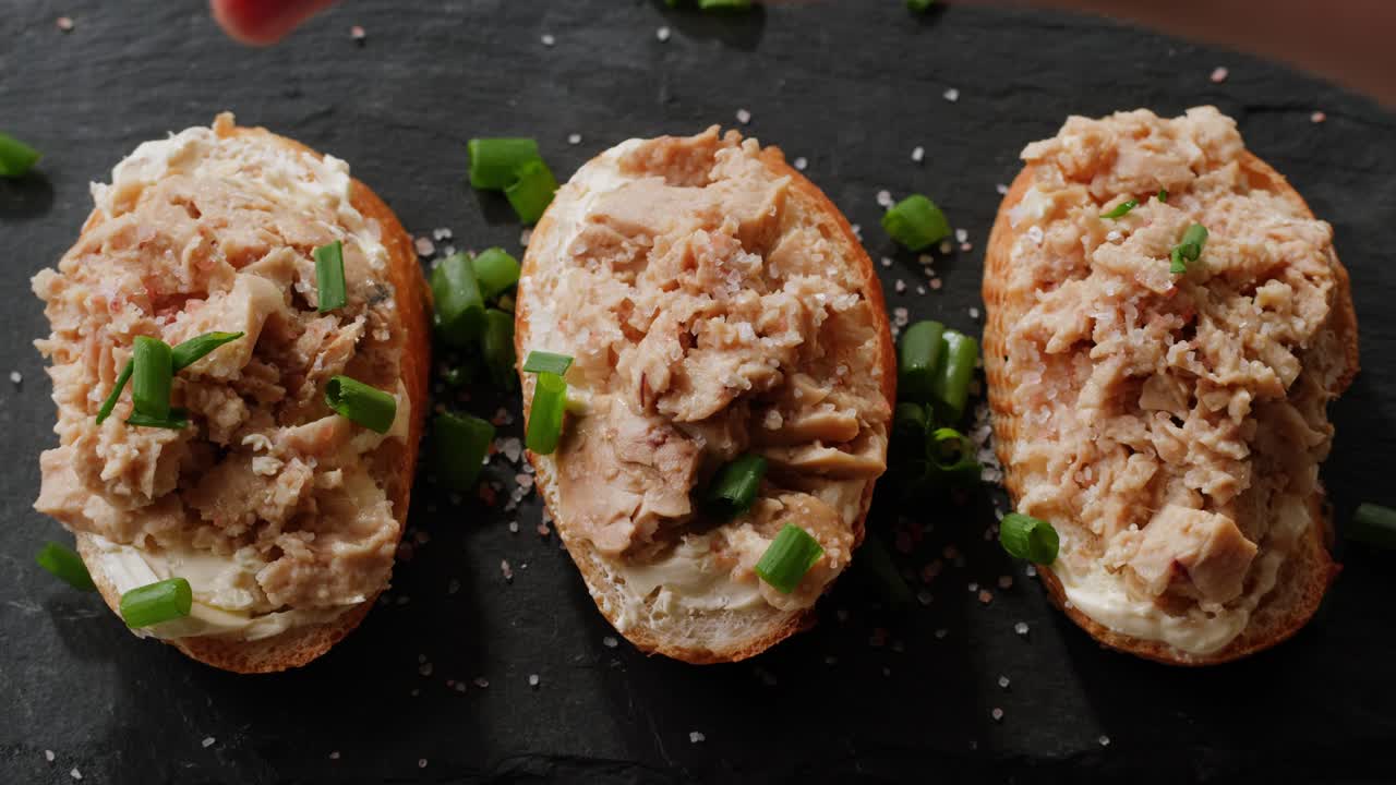 Smoked cod liver in oil in open tin can with fresh greens on wooden table. Seafoods delicacy. High quality 4k footage