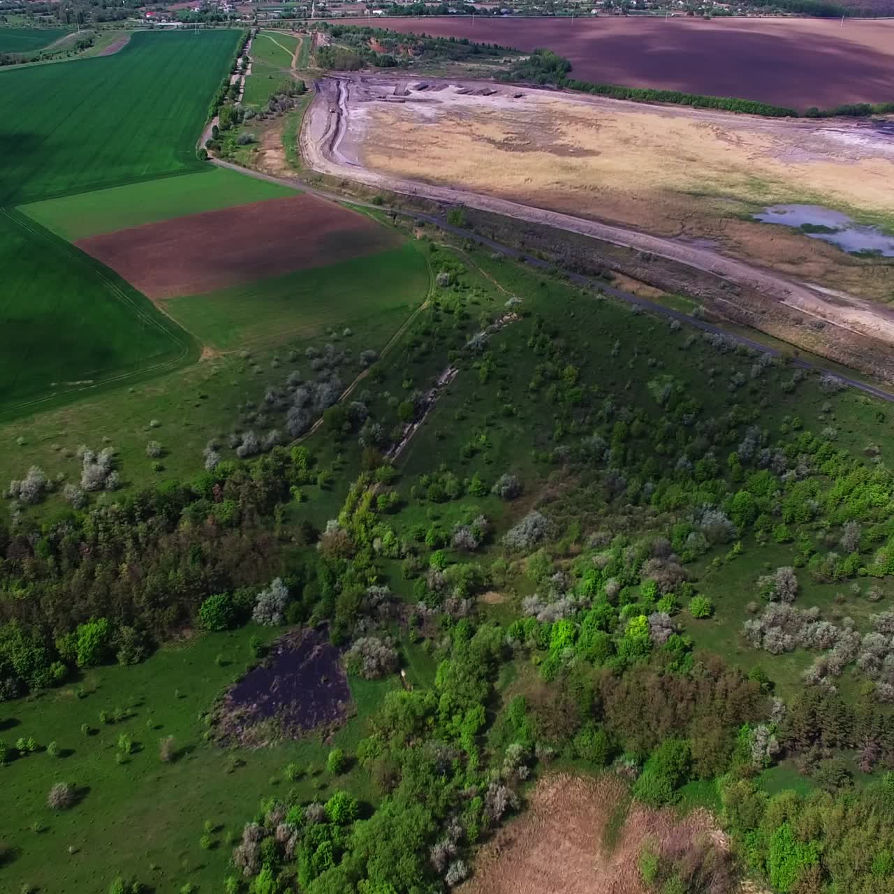 Beautiful diverse natural landscape outside of a big city. Clouds throwing shadows on the ground. View from top