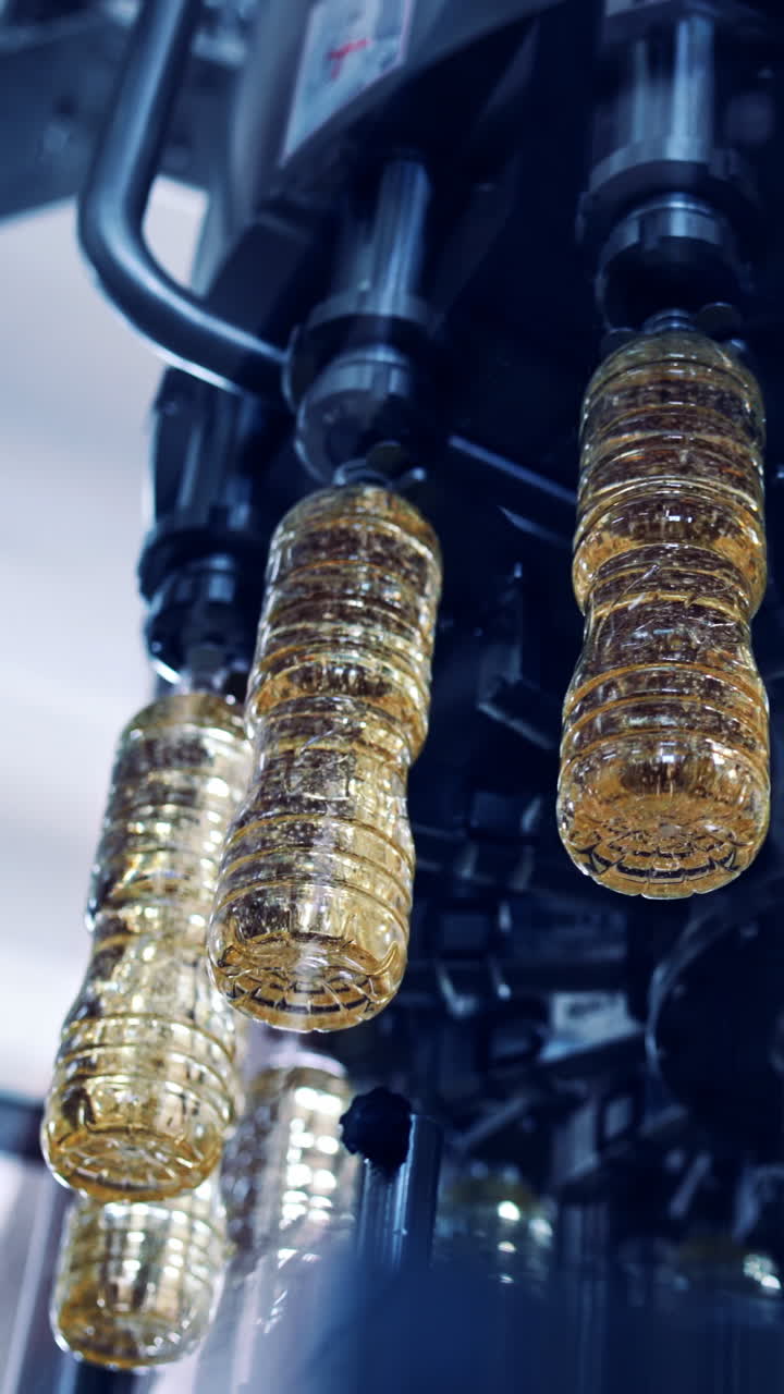Factory for production of oils. Sunflower oil filling in the bottle, moving on production line Vertical video
