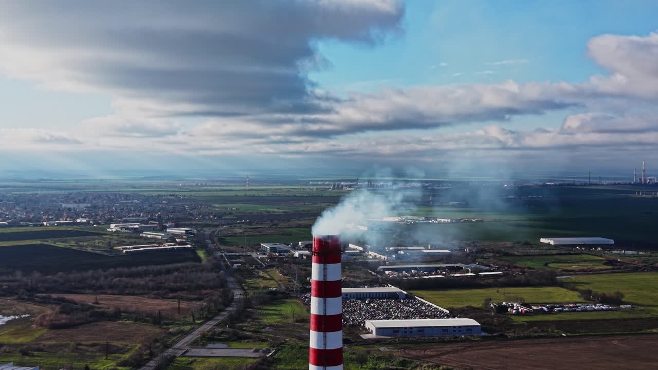 Zona industriale con ciminiere di fabbriche e cielo nuvoloso di giorno