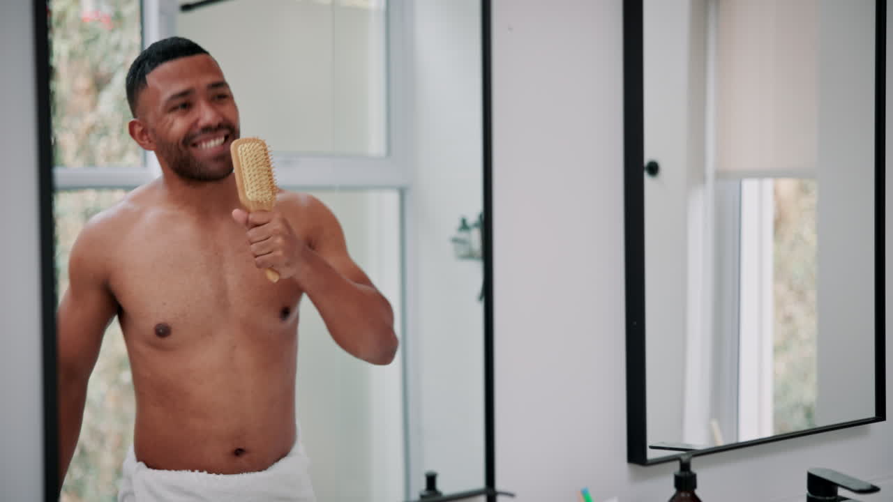 Man singing into hairbrush in bathroom mirror