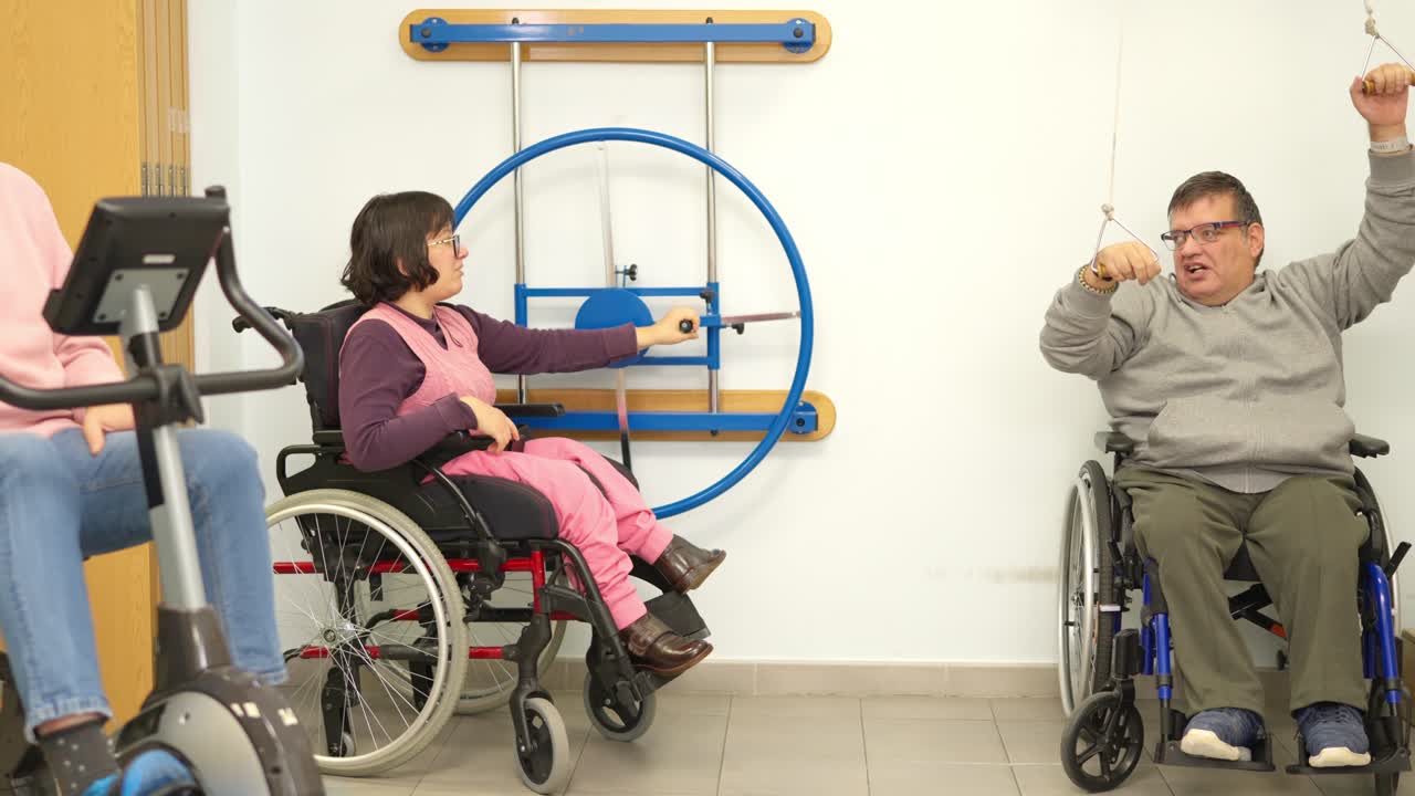 Personas en silla de ruedas haciendo ejercicios de rehabilitación en un centro de terapia