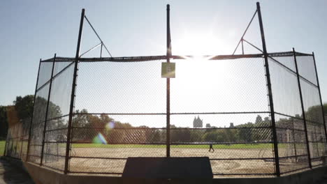 Leerer-Baseballfelddiamant-Im-Park,-Einzelne-Person-Geht-Allein-Vorbei