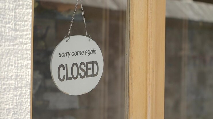 Closed Sign Hanging on a Glass Storefront Door