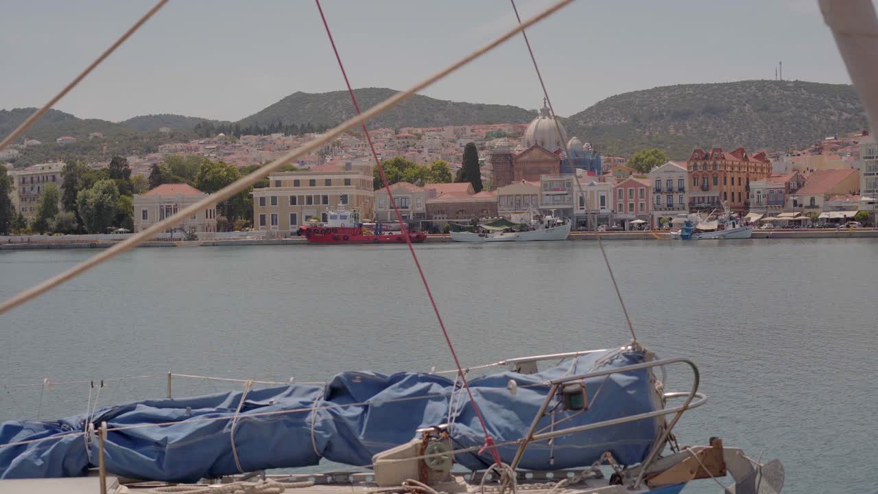 Mytilene harbour view with city historical buildings, church, and boats in view, POV