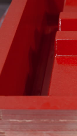 primer plano de un cajón de caja de herramientas mecánicas roja, destacando el acabado brillante y los agujeros cuadrados de precisión