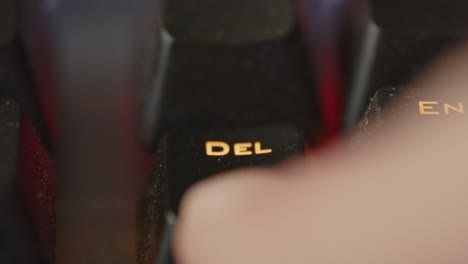 macro view of delete key on led keyboard being tapped repeatedly