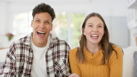 Happy-diverse-couple-sitting-on-sofa-having-video-call-at-home,-in-slow-motion