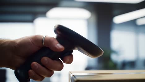 a close-up of a hand using a barcode scanner to scan a package in a modern office environment, highlighting the efficiency of inventory management and retail technology