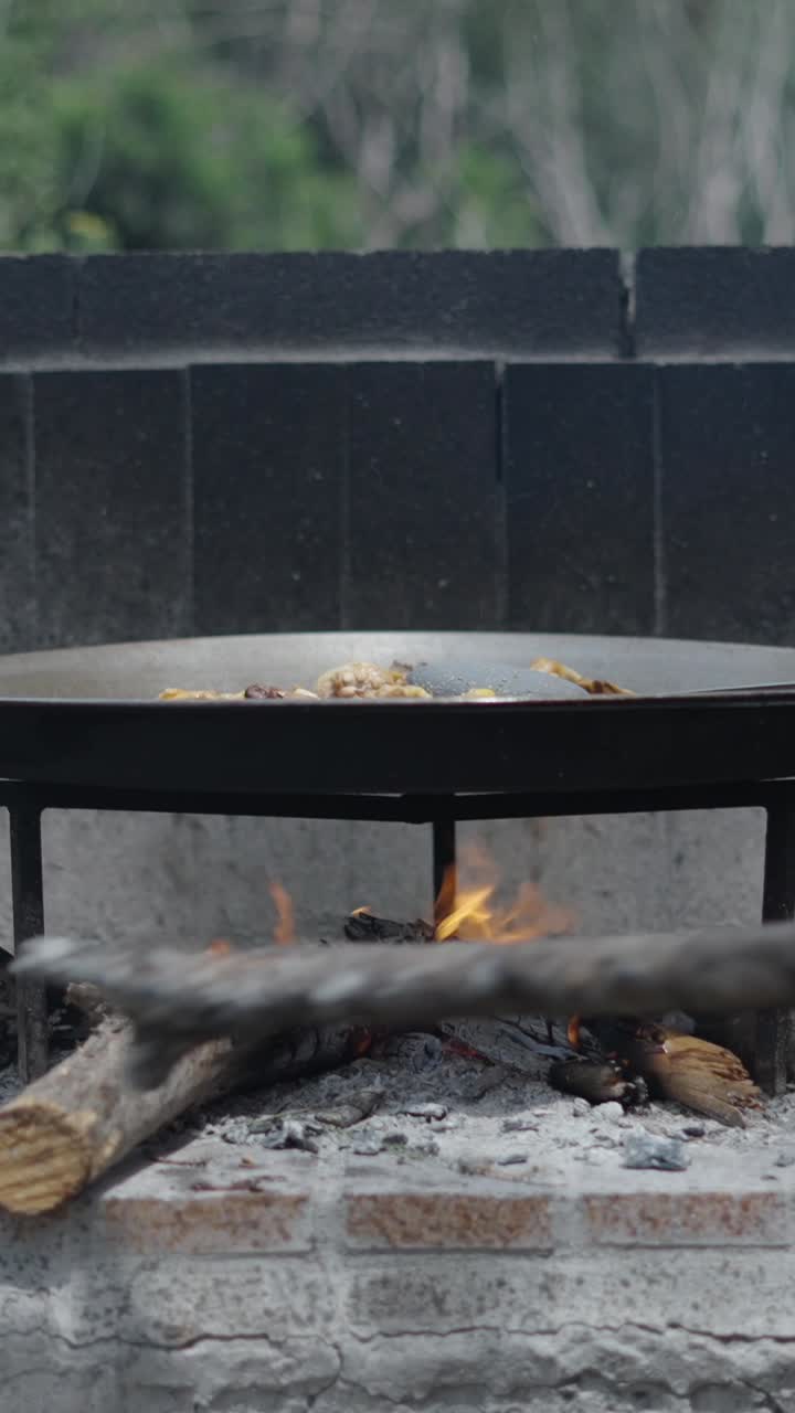 Cooking paella over a wood fire outdoors