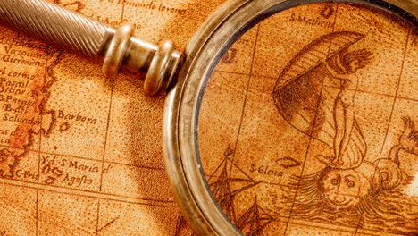 vintage magnifying glass lies on an ancient world map in 1565