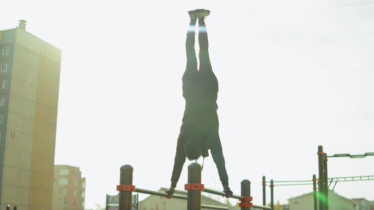 Sportsman Doing Handstand on Parallel Bars at Workout Playground