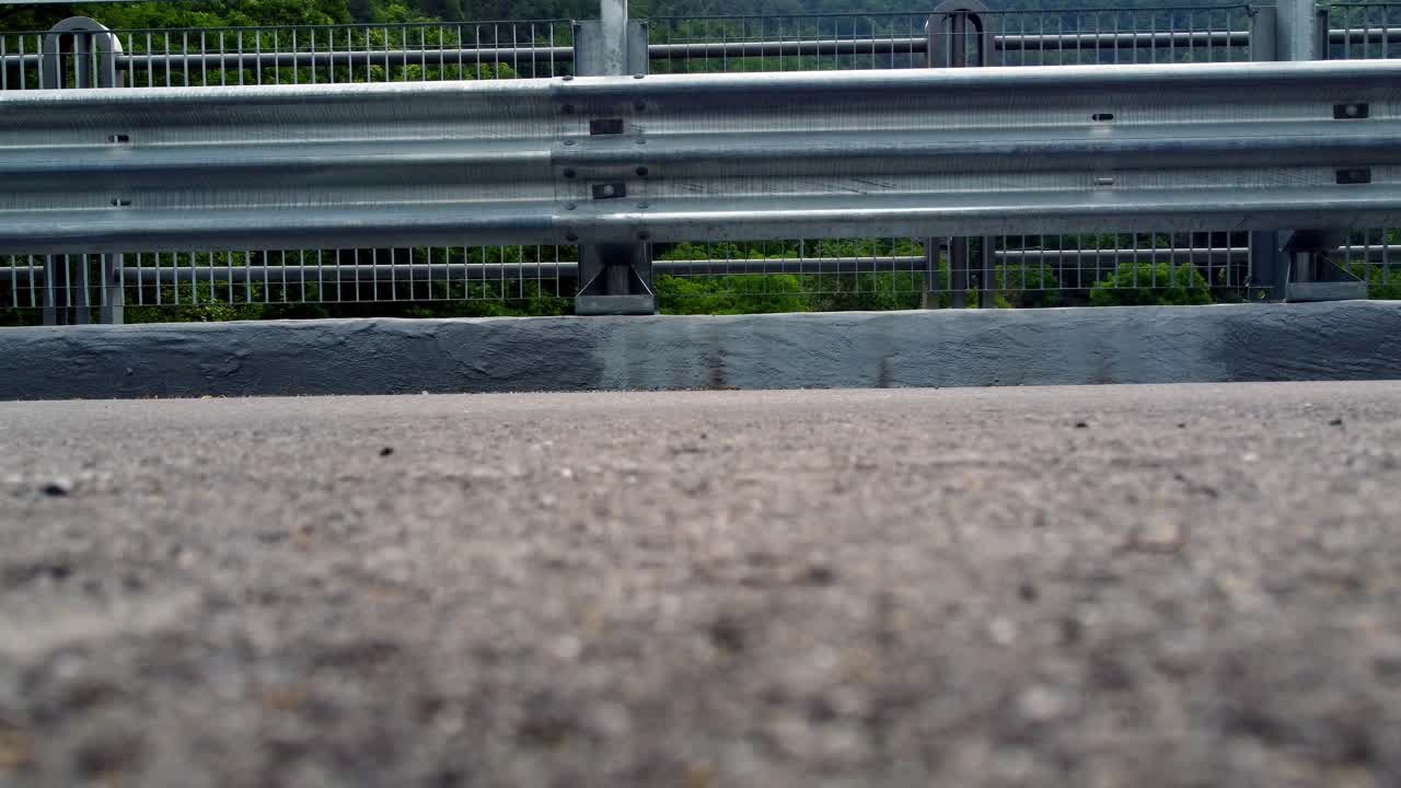 disparo a nivel del suelo en la calle mientras la gente pasa sobre el asfalto en val maira, cuneo, italia