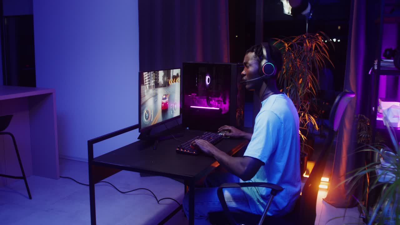 Gamer playing video game at computer desk