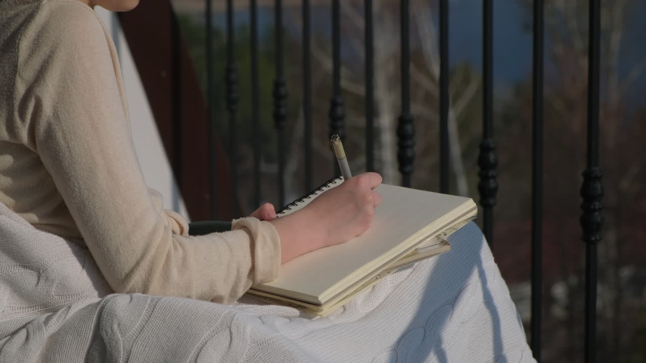 Woman Writing on Balcony