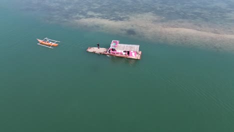 Ein-Schwimmendes-Häuschen,-Das-Von-Einem-Kleinen-Boot-Gezogen-Wird-Und-Nach-Einer-Tagestour-An-Einer-Sandbank-Zum-Anlegen-Bereit-Ist