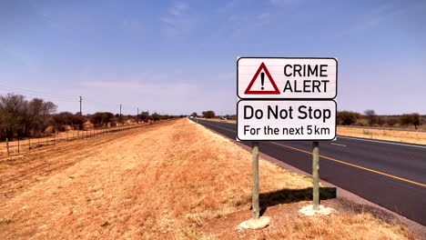 crime alert warning road sign next to south african highway advising not to stop