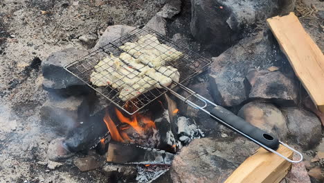 Hühnerfleisch-Auf-Dem-Grill,-Flammen-Und-Rauch-Vom-Grill,-Camping-Kamin-Im-Sand,-Zeitlupe,-Statische-Aufnahme