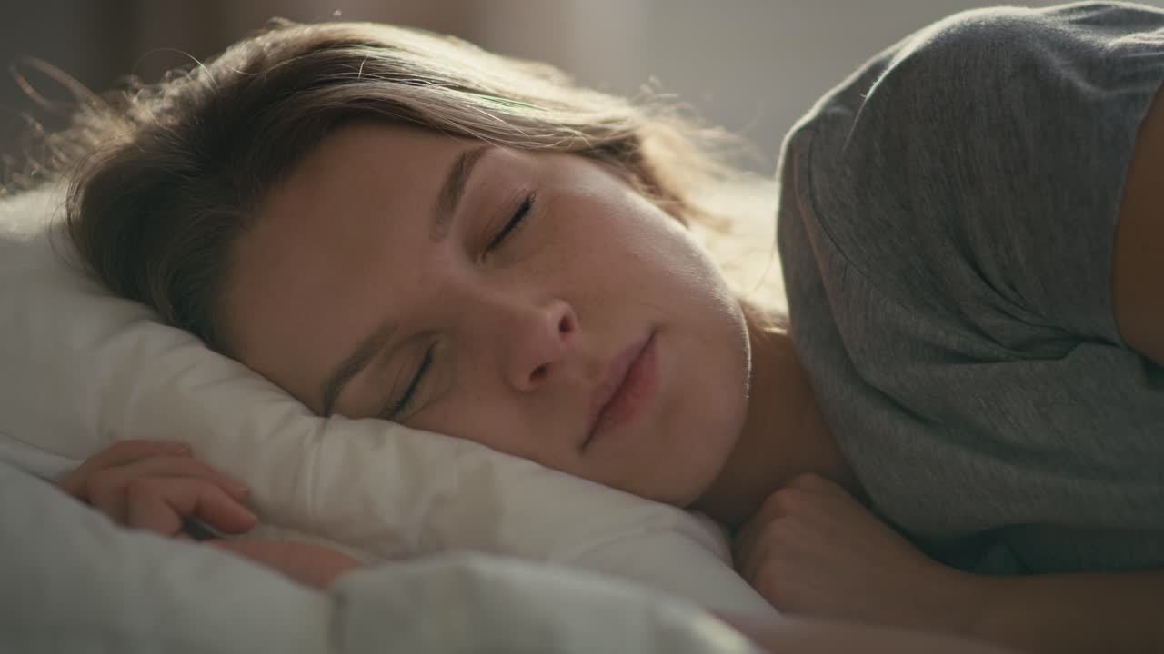 침대에서 자고 있는 백인 여성의 클로즈업