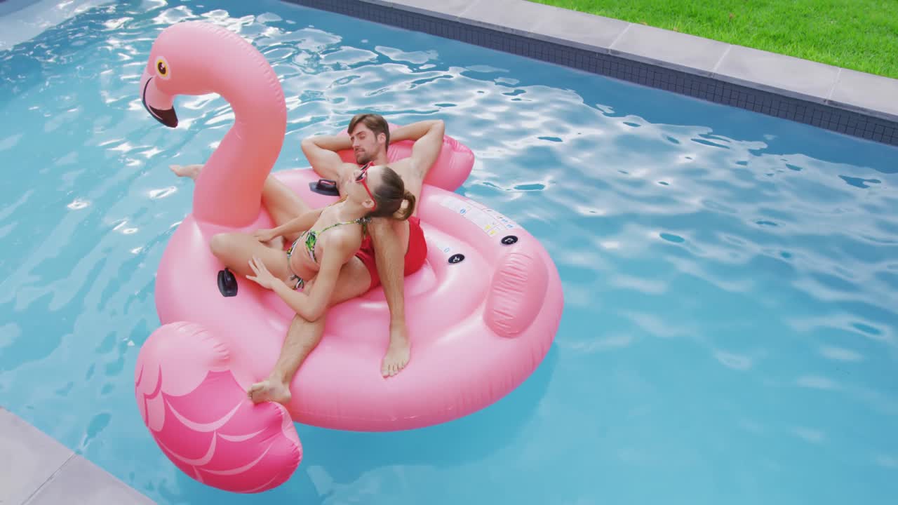Couple sleeping together on inflatable tube in swimming pool 4k