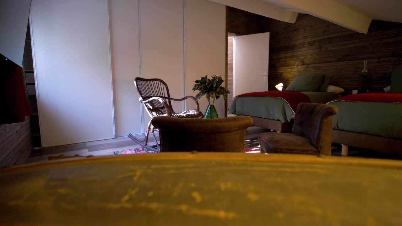 Lenta inquadratura di apertura di una camera da letto decorata di verde all'interno di una mansarda di villa