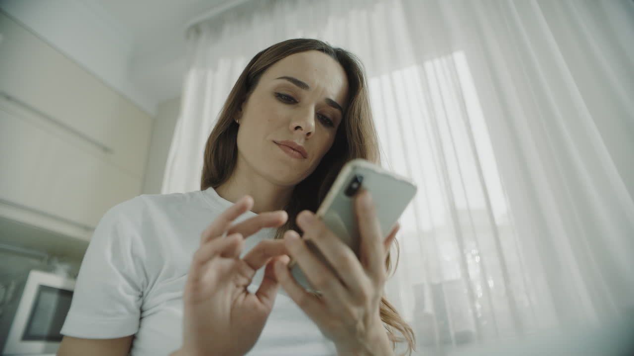mujer joven usando teléfono móvil en casa. primer plano de chica usando teléfono inteligente