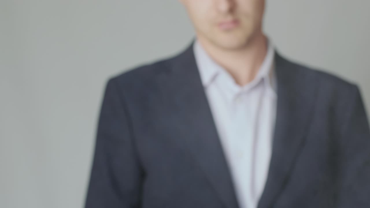 un hombre de negocios en una chaqueta con un arma en la mano recarga el perno y está listo para disparar