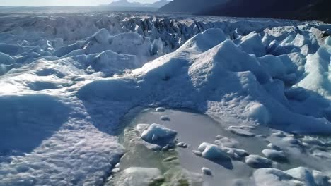 explore the breathtaking sight of a glacier in iceland where vibrant ice formations contrast against a clear blue sky. the ice stretches across the landscape, showcasing the beauty of nature.