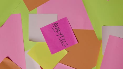 business concept of revolving sticky notes with analytics written on top note