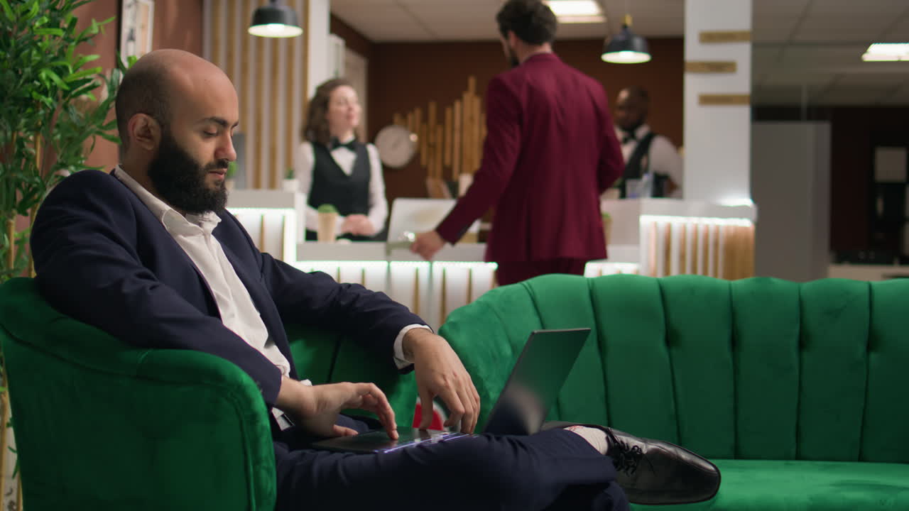 Investitore che esamina gli appunti sul portatile in hotel