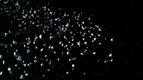 Animated-stone-particles-on-dark-background,-simulation-of-stones-and-small-rocks-moving-slowly-under-sunlight-in-asteroid-belt,-cosmic-derbies-concept